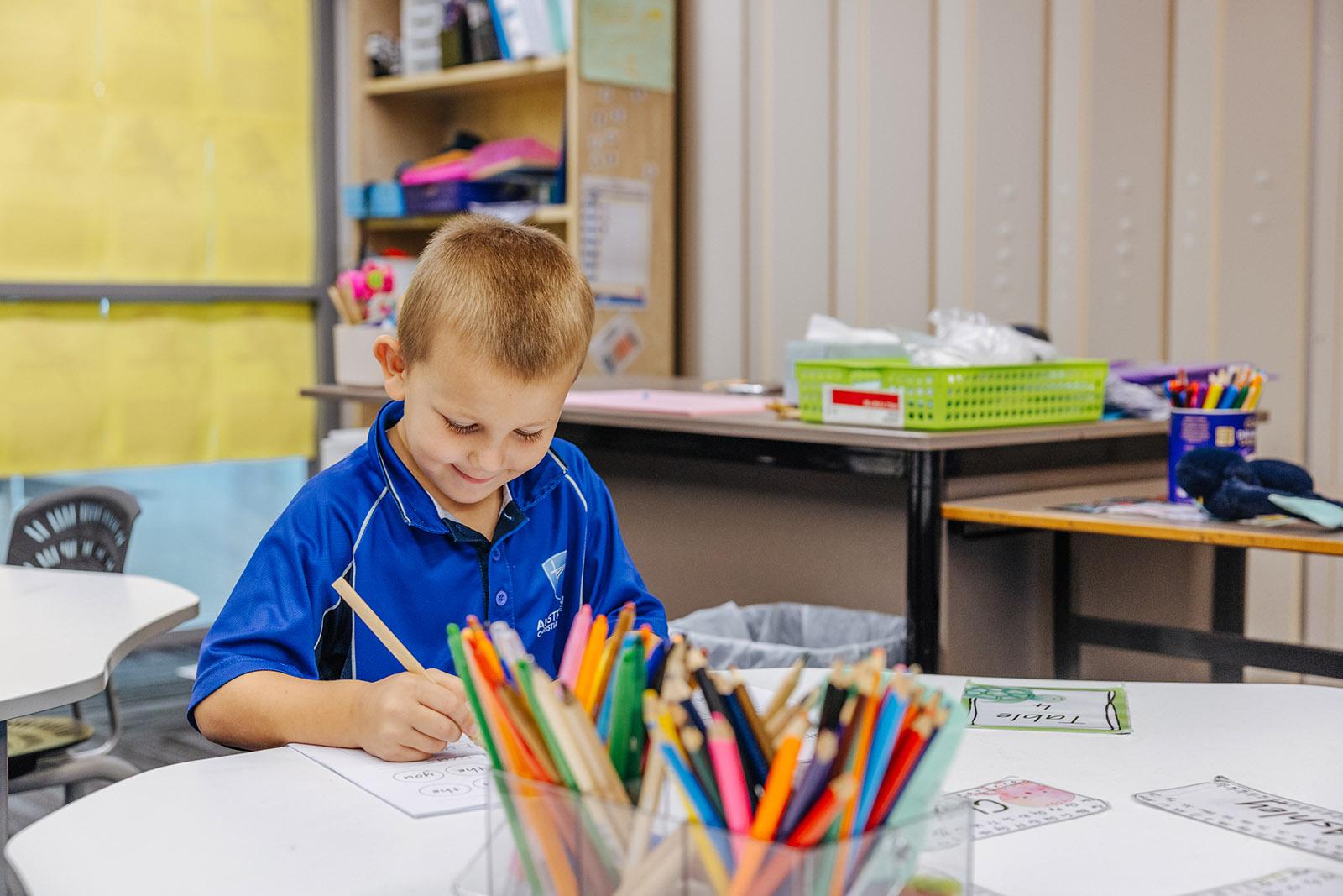 Prep student practicing early writing skills in a classroom at ACC Moreton