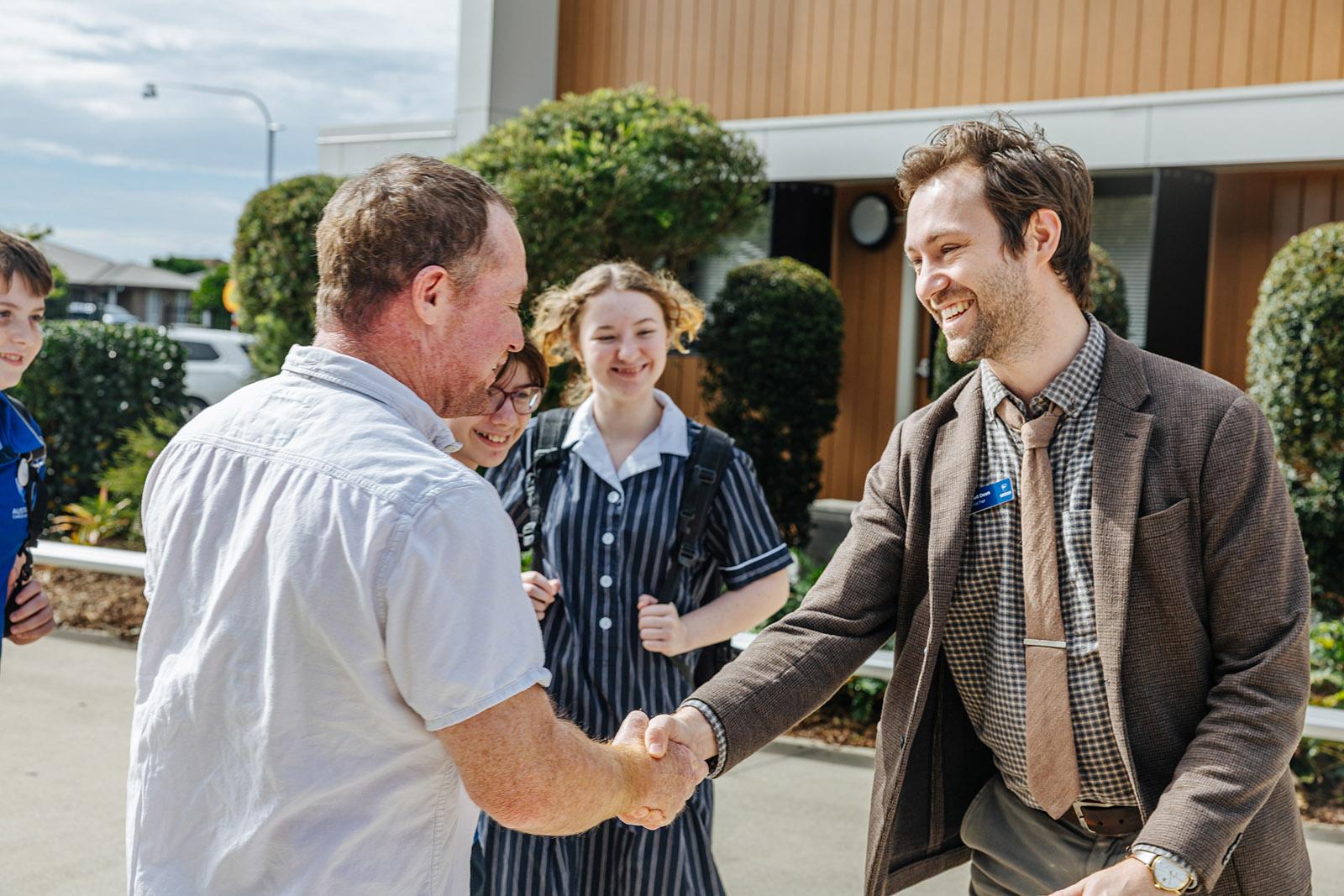 Teacher greeting a parent as students arrive at ACC Moreton
