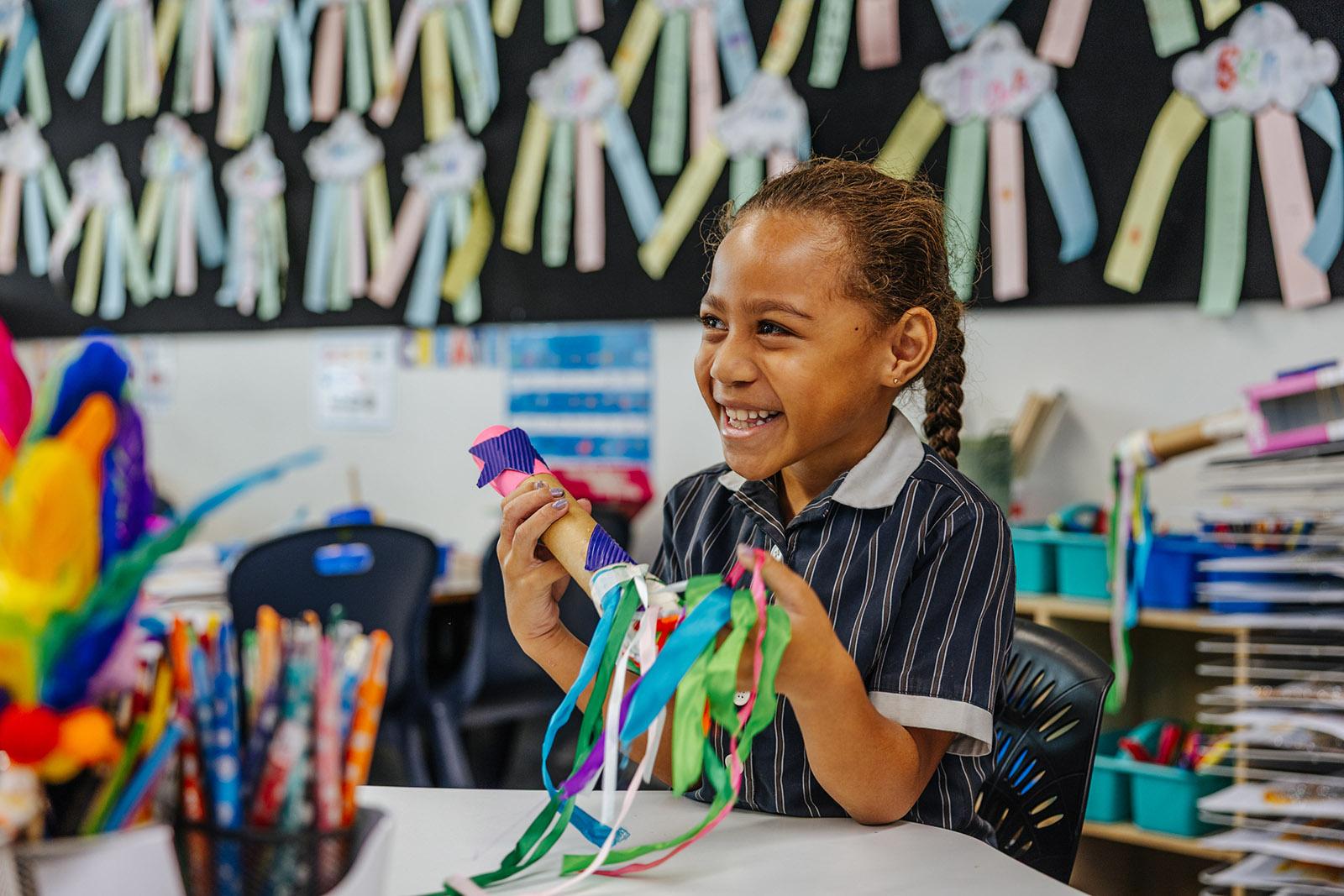 Primary student creating a colourful craft project in class at ACC Moreton