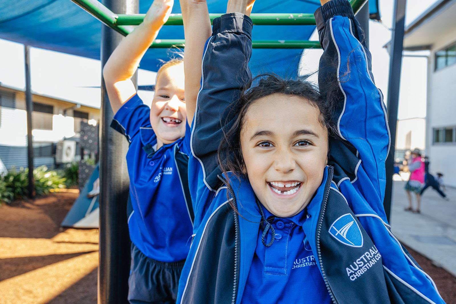 Primary students building confidence on the playground monkey bars at ACC Moreton