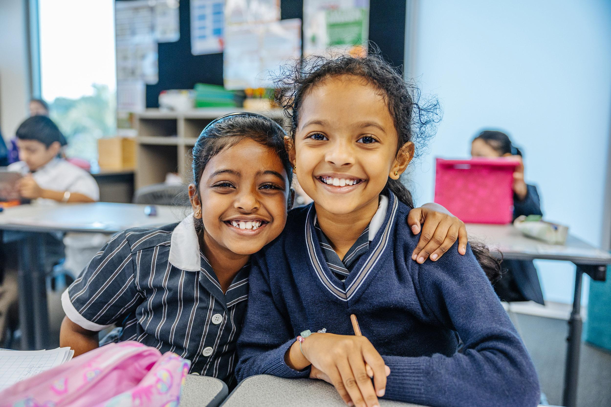 Two ACC Moreton students smiling together in a classroom