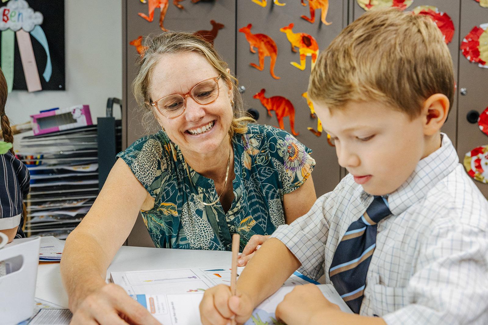 Teacher guiding primary students using tablets during classroom practice