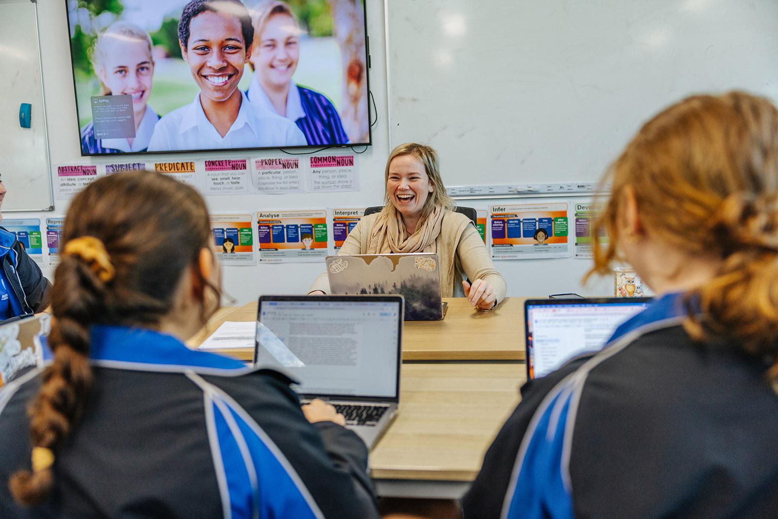 Teacher supporting a primary student during a classroom learning activity