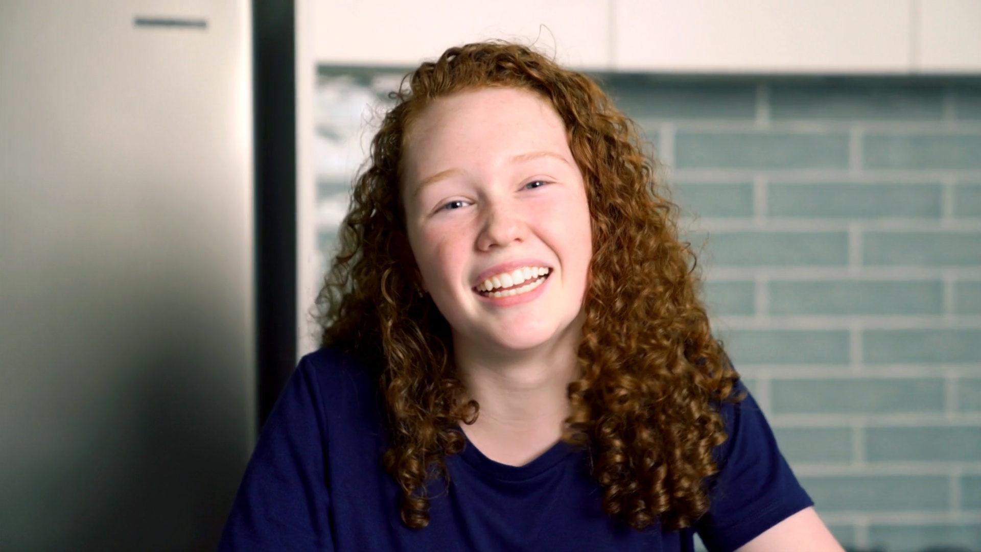 smiling female teenage distance education student with curly hair