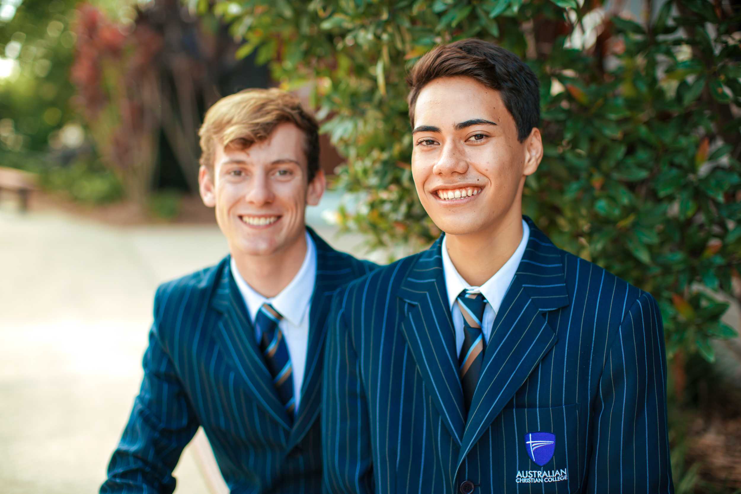 smiling high school students in uniform wearing blazers