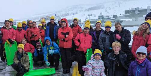 Distance education students wearing beanies and jackets on snow trip