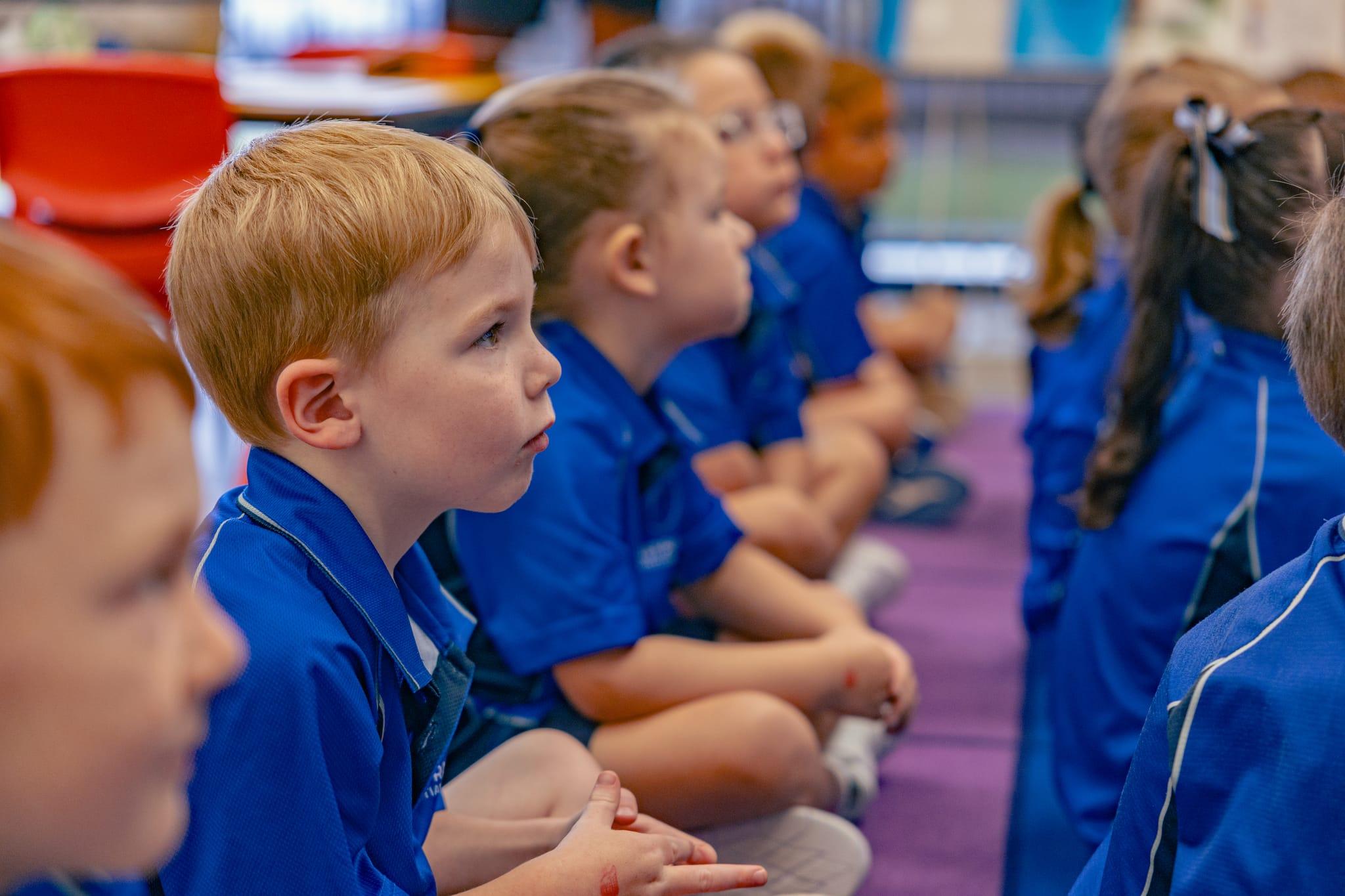 Prep students sitting attentively on the carpet during group time, beginning their school day in a calm and structured way.