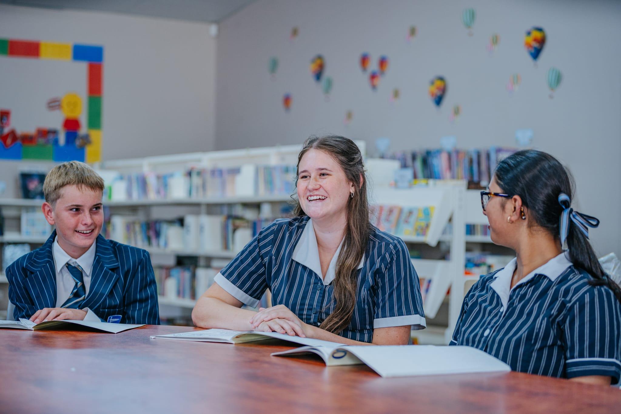 Senior students sharing a positive discussion in the school library, reflecting Christian values of respect, community, and character development.