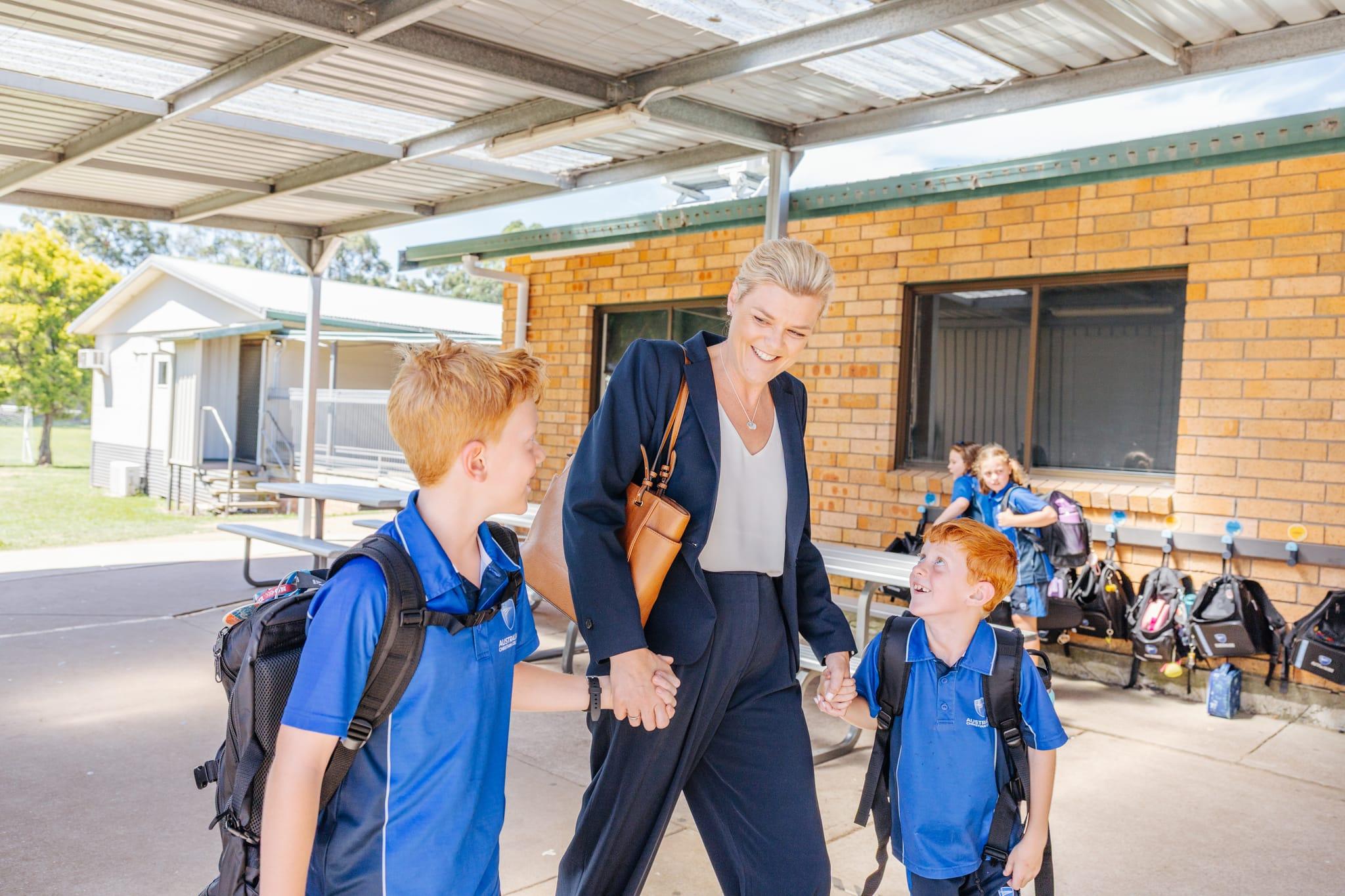 Smiling parent walking two children into ACC Singleton, symbolising strong school-family partnerships and community connection.