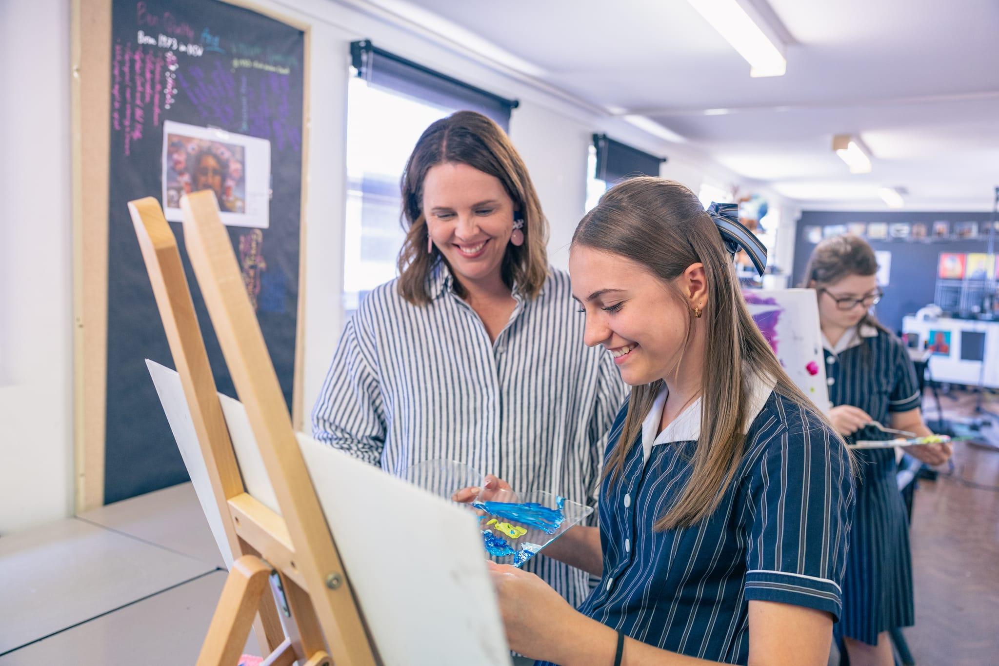 Art teacher encouraging senior student at ACC Singleton, reflecting creativity and care in a Christian learning community.