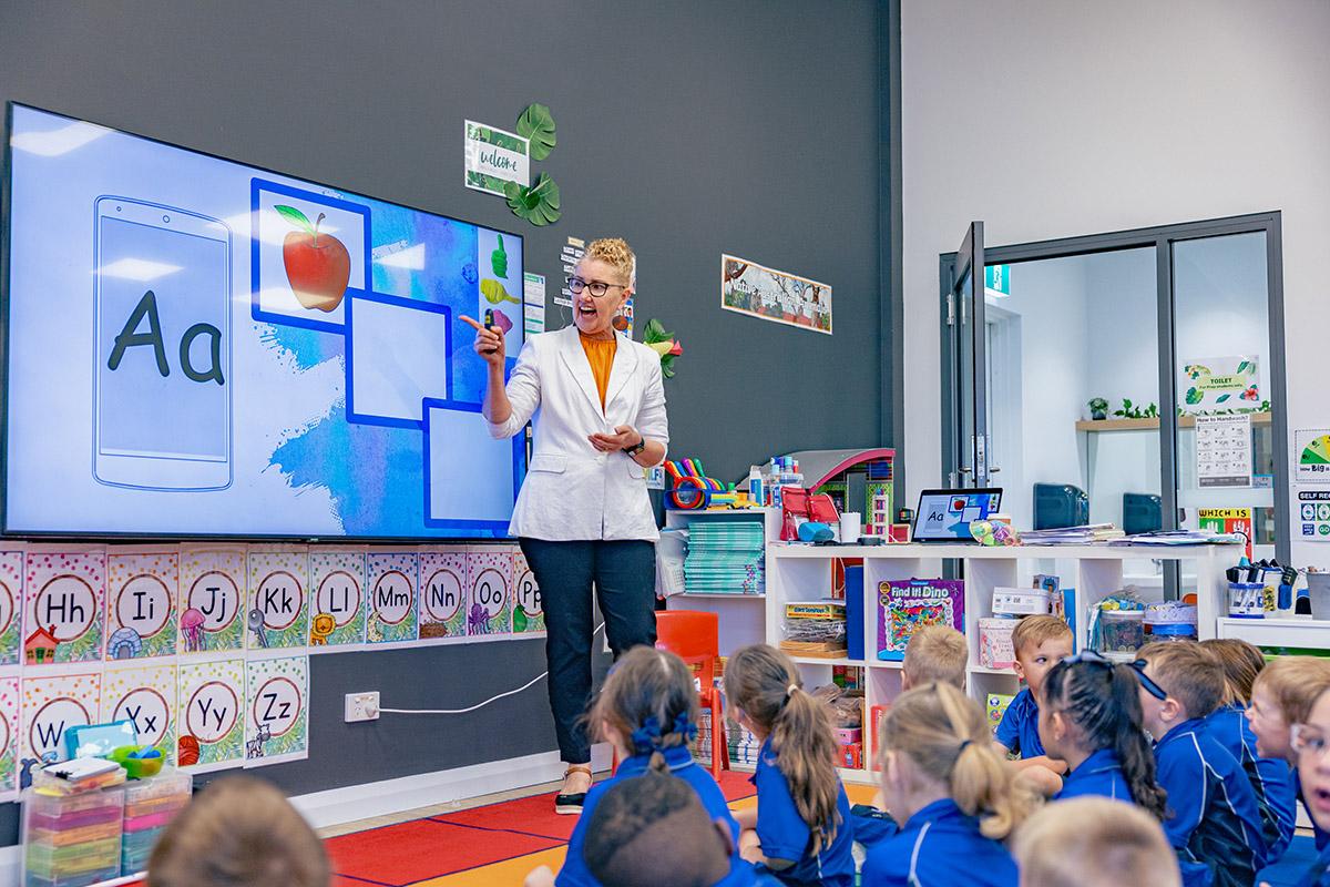 Supportive Prep teacher leading a phonics lesson with young students during a literacy-focused classroom session.