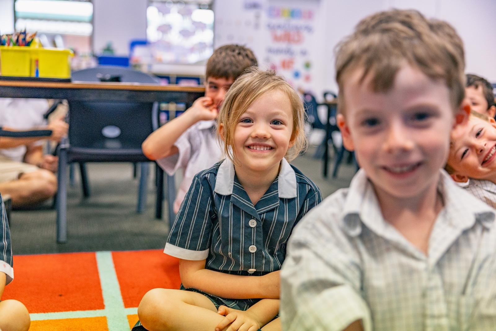 Young students smiling in class at ACC Singleton, illustrating the school’s commitment to knowing each child personally