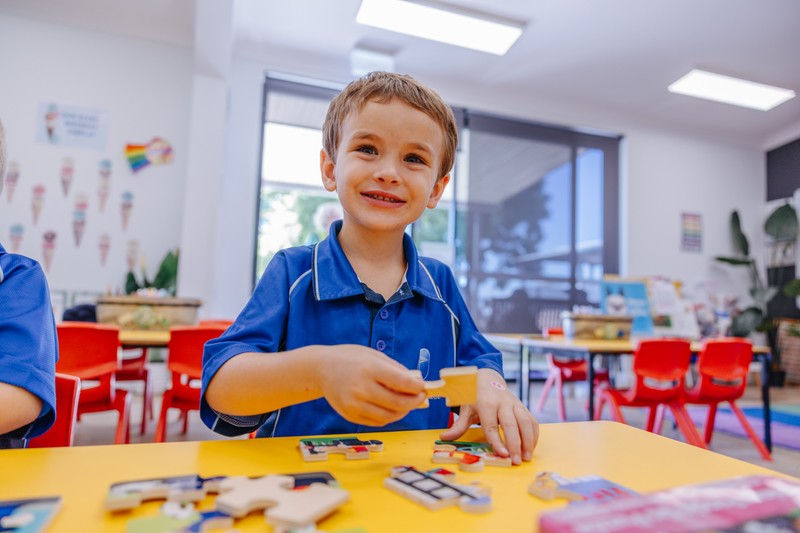 Kindergarten girl actively learning playing with blocks in classroom