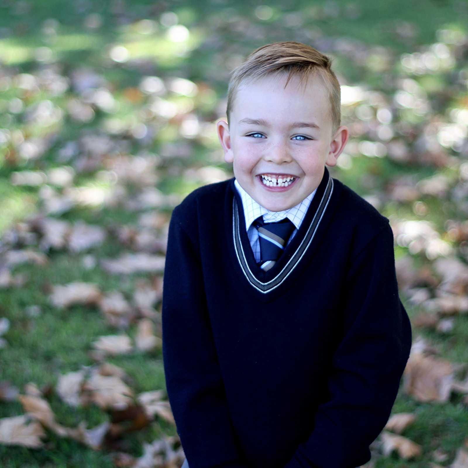 Smiling boy in ACC school uniform jumper