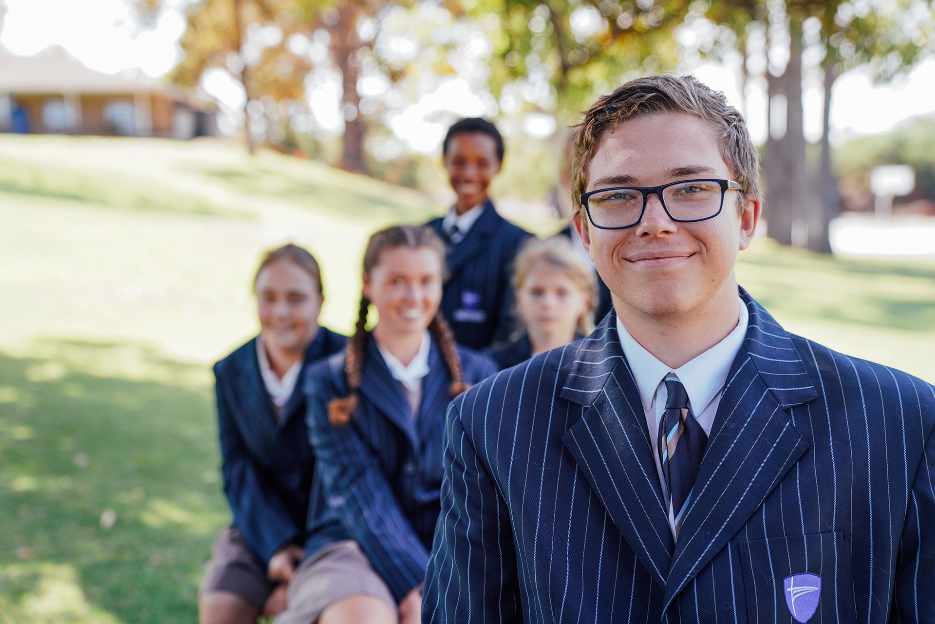 Smiling ACC Singleton high school student with friends in the background