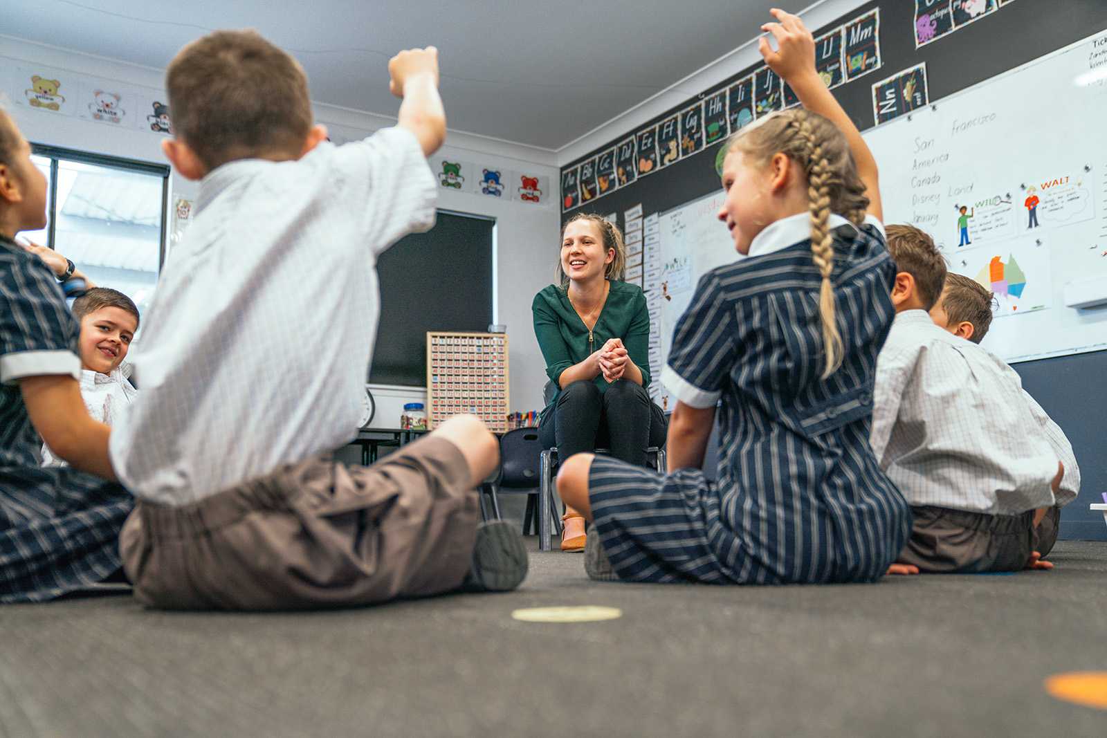 teacher in classroom engaging with primary school students