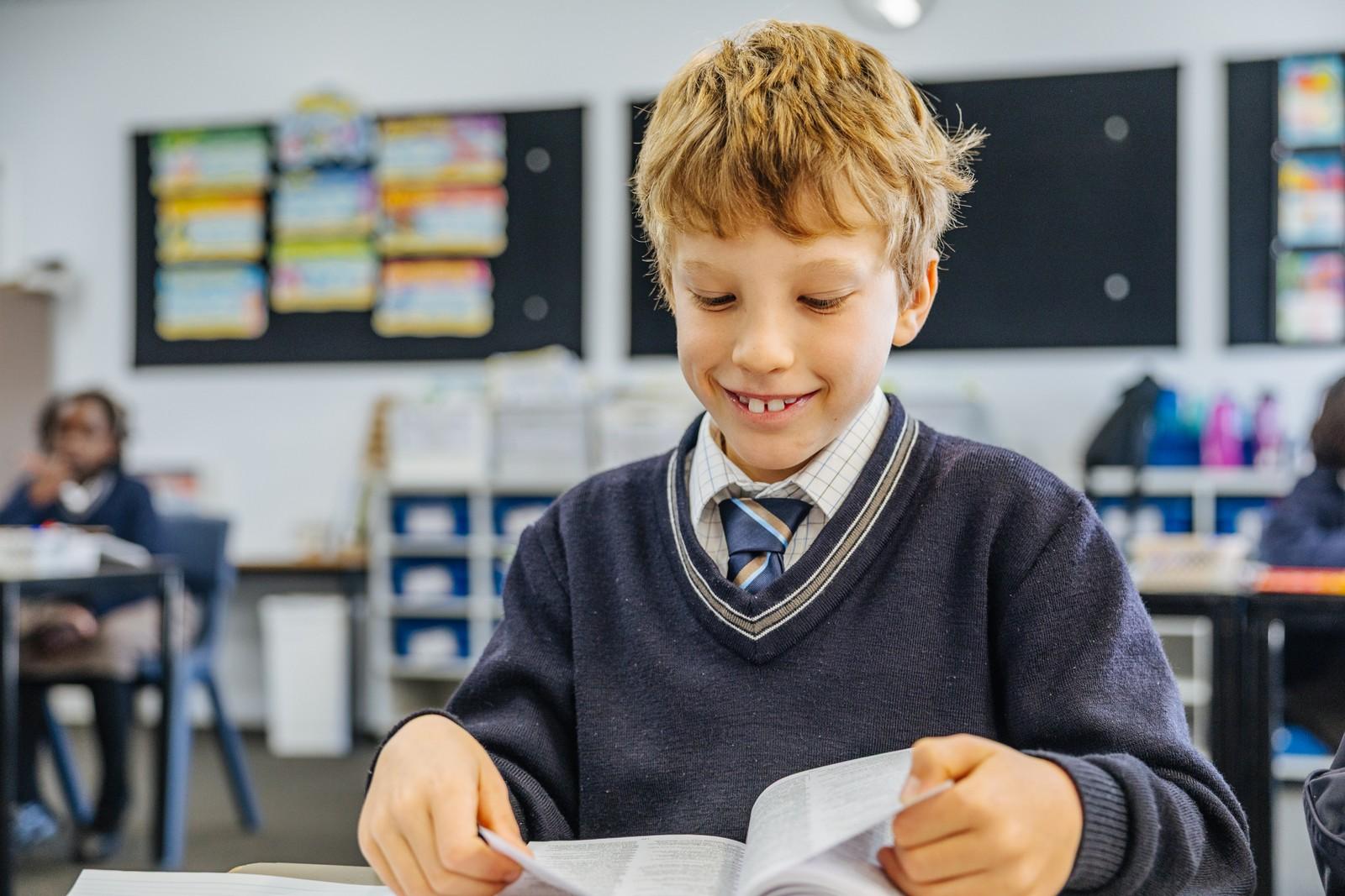Primary boy reading at his desk in an ACC Southlands classroom