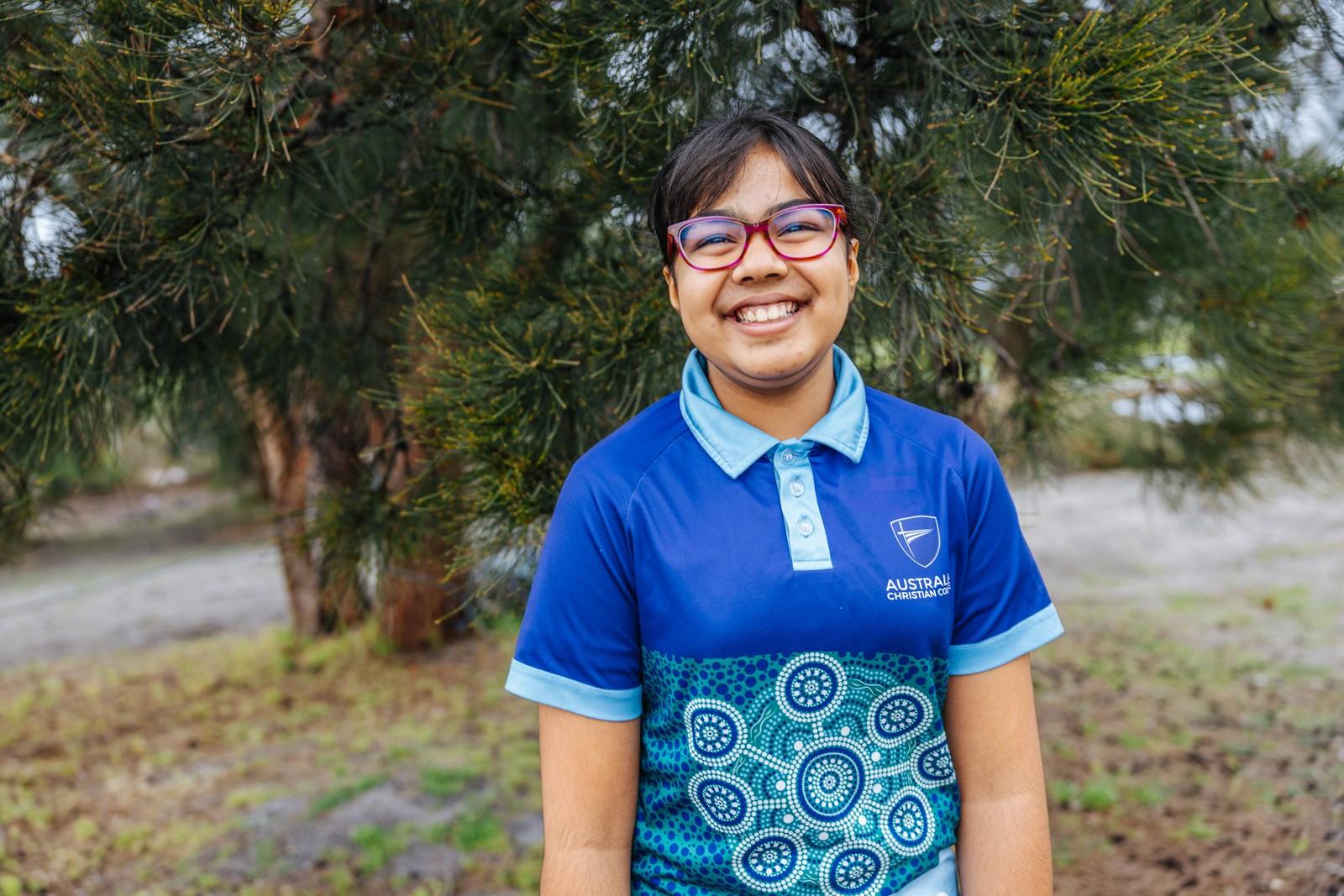 Smiling primary girl in ACC uniform outdoors at Albany school
