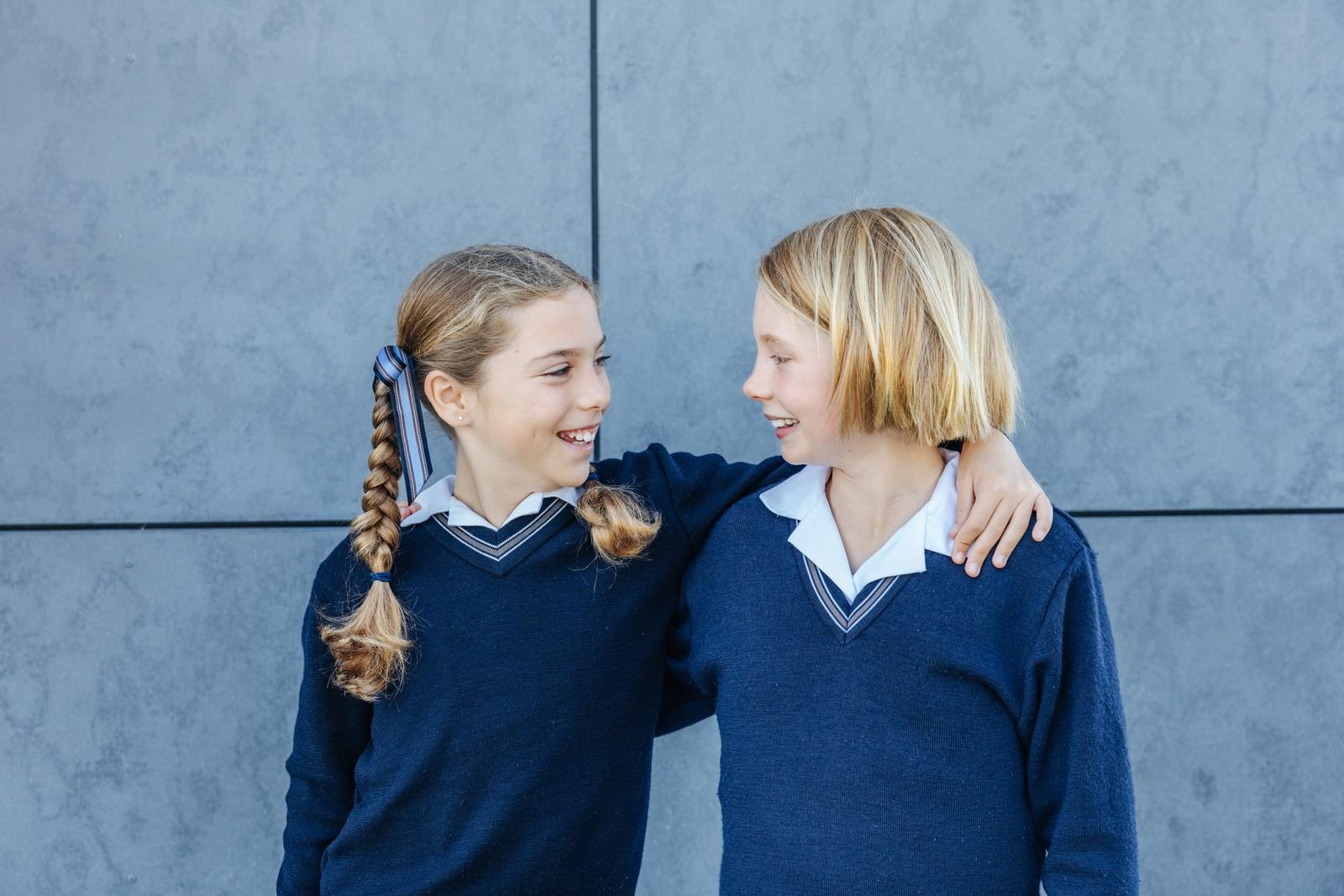 Two Albany primary school girls laughing together in ACC uniform