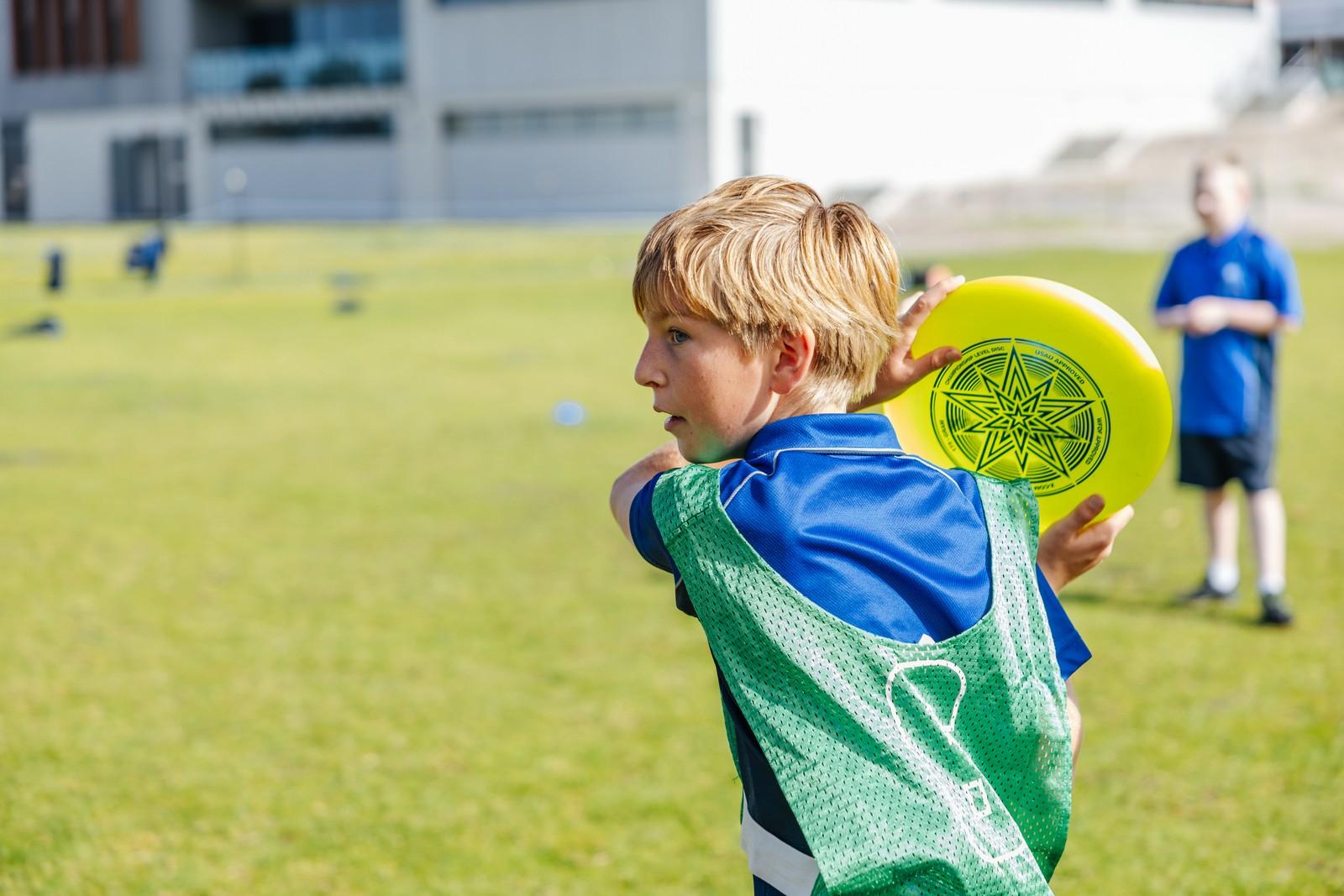 Primary student throwing a frisbee during sport at a Collingwood Heights school