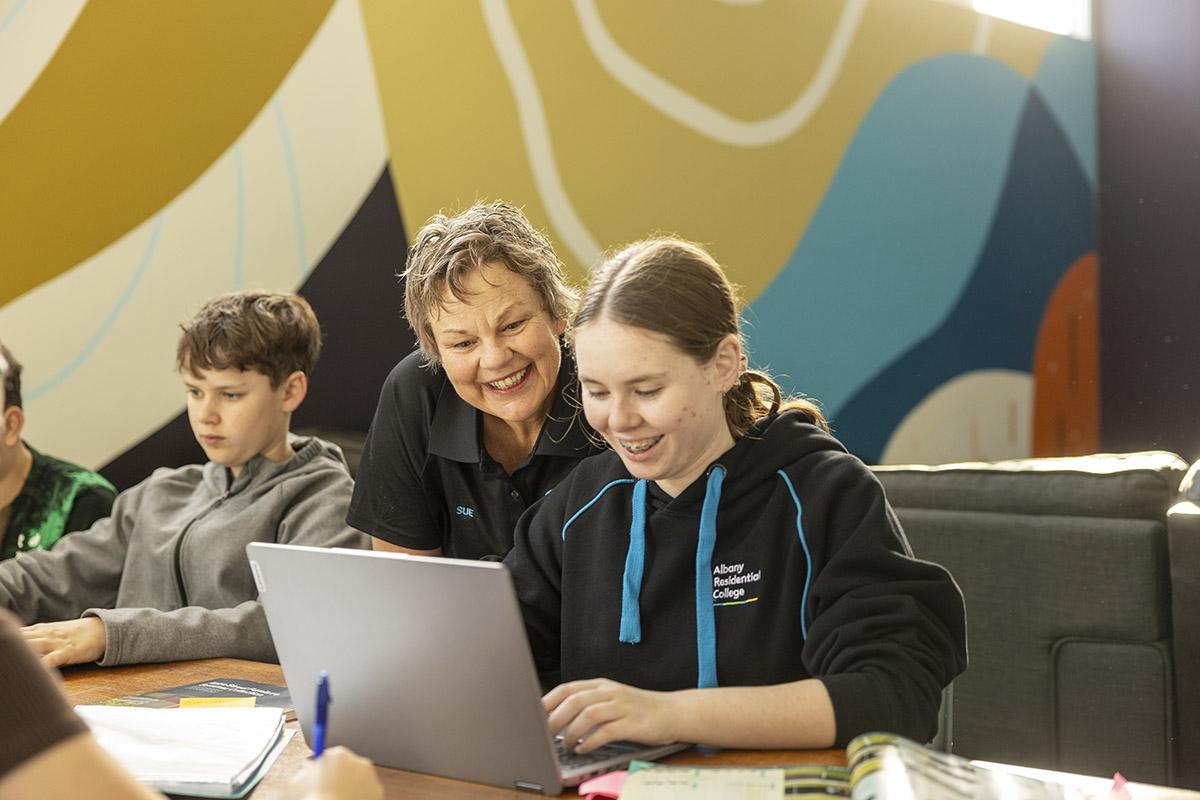 Boarding staff member helping students with their homework