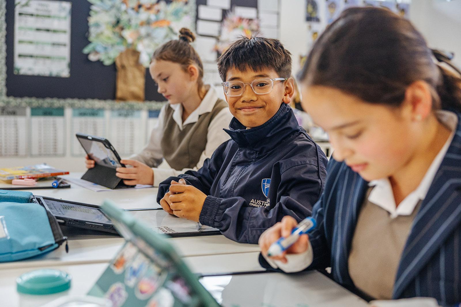 Upper primary student wearing a jacket sitting at a desk in a modern ACC Southlands classroom