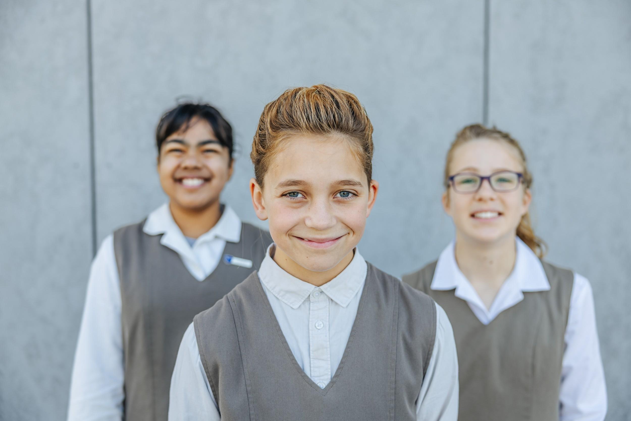 Three primary students in ACC Southlands formal uniform outdoors