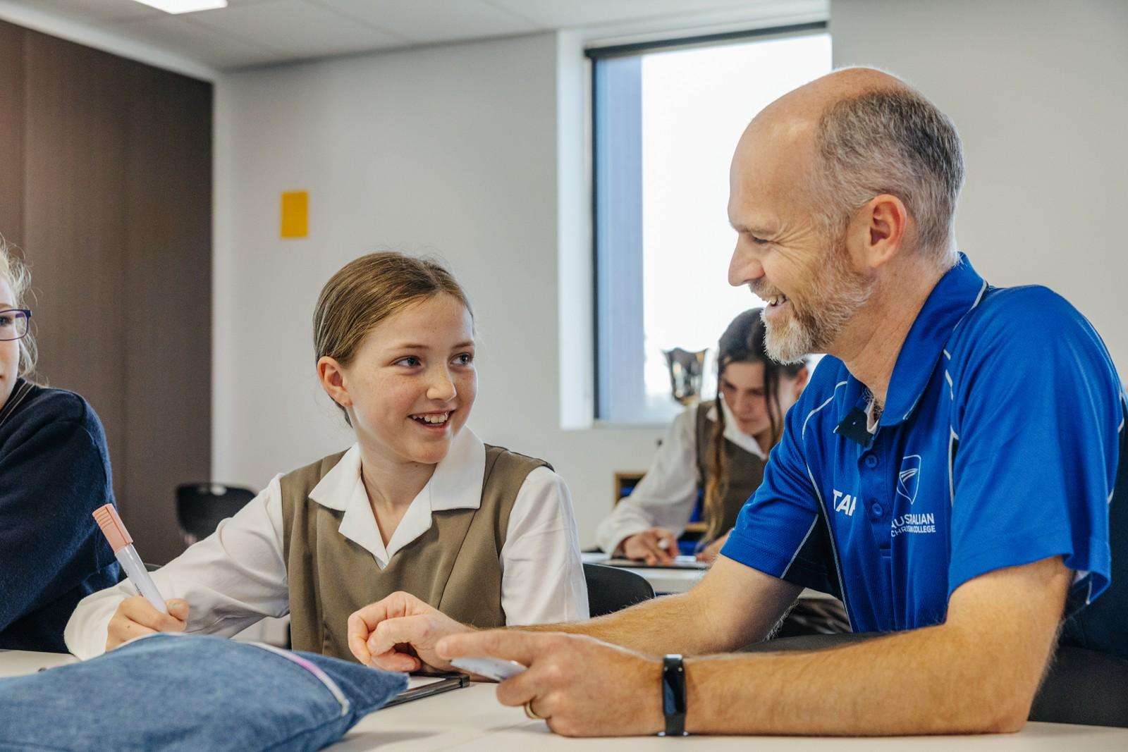 ACC Southlands teacher supporting a primary student at their desk in the classroom