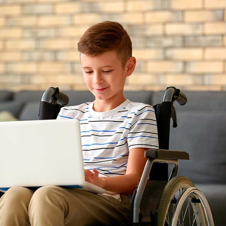Wheelchair bound student using a laptop to complete online school lesson
