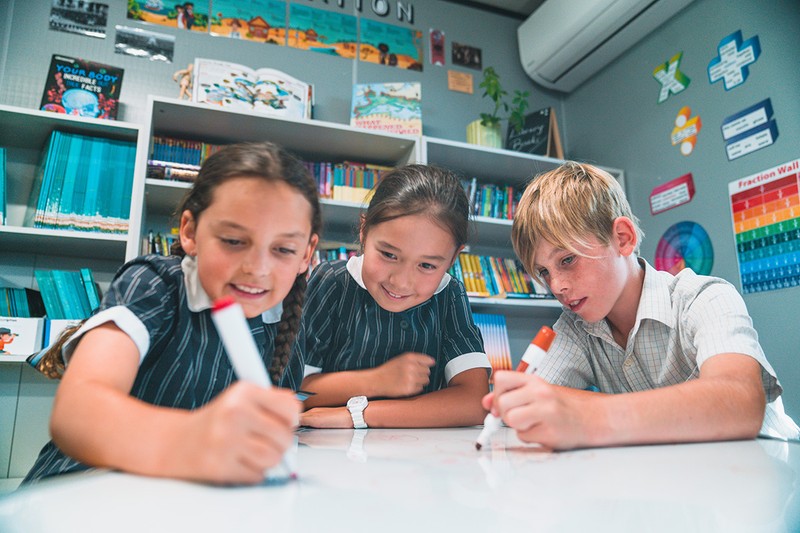 Primary classroom students drawing together at table