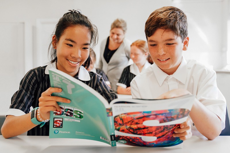 Year 7 boy and girl reading book together