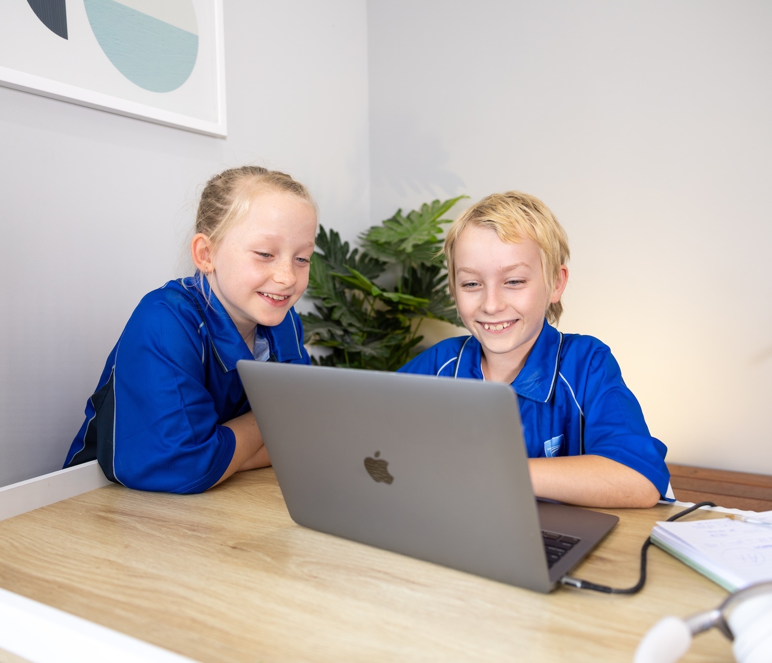 Girl with platted hair wearing headphones while completing schoolwork online from ipad