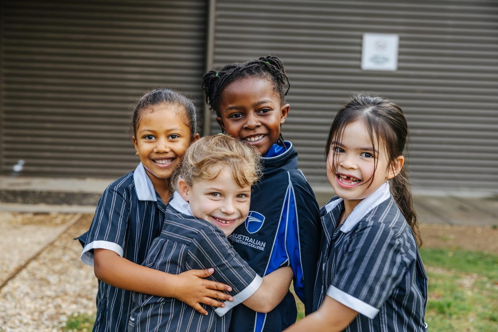 Four primary students smiling together at ACC Victoria